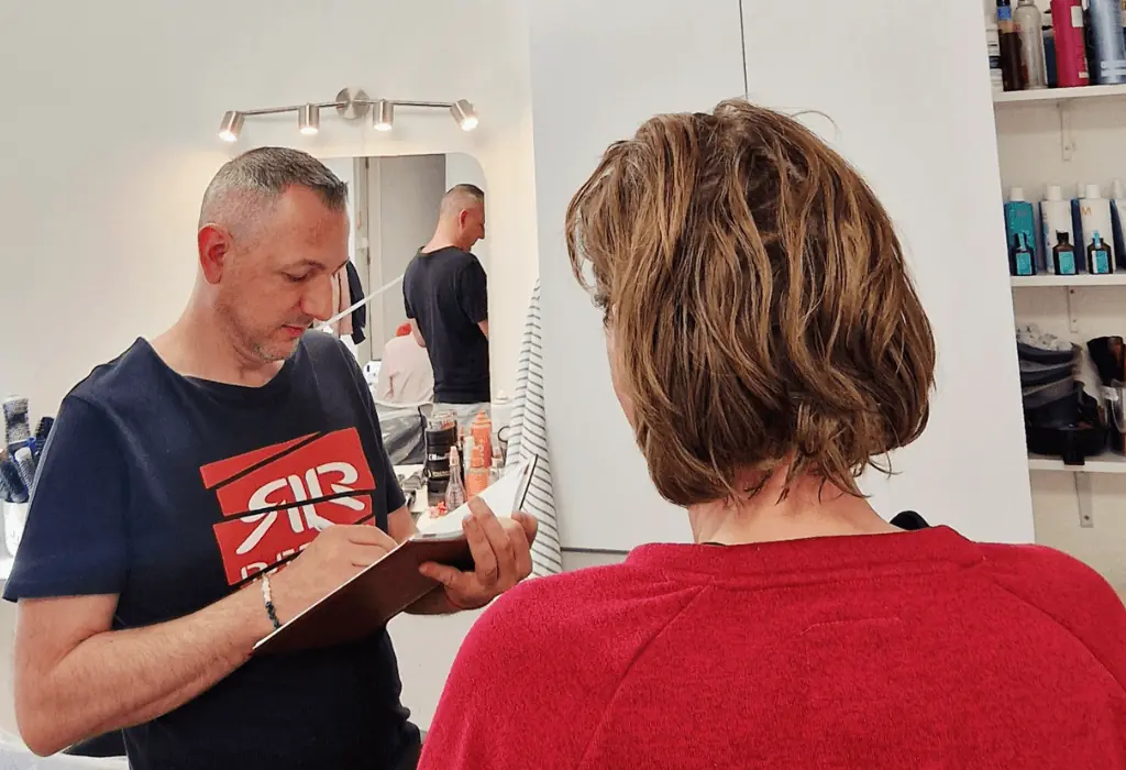 Világosbarna, rövid, réteges bob frizurájú vendég fodrászati konzultáción